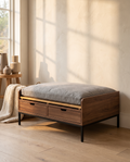 Elevated wood pet bed with storage drawers on slim metal legs in a warm neutral interior