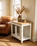 White dog crate table with oak top used as an end table beside a leather sofa