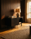 Black espresso litter cabinet with tapered feet against walnut panelling