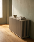 Greige slatted dog crate side table used as a hallway console