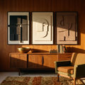 Three sandstone-textured brown and beige panels above a walnut sideboard