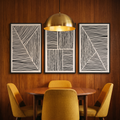 Three minimalist black-framed line prints in a mid-century dining nook
