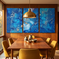 Blue abstract three-panel canvas above a teak dining table